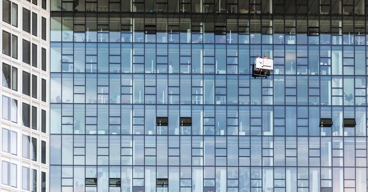 Fensterreinigung an einer Gebäudefassade, Symbolbild